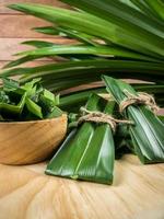 pandan e foglie di pandan in una tazza di legno preparata per il succo di pandan o la torta di pandan da far bollire o essiccare prima di andare a cucinare. girato in studio foto