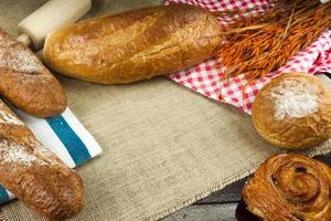 diversi tipi di pane fresco sulla tavola di legno foto