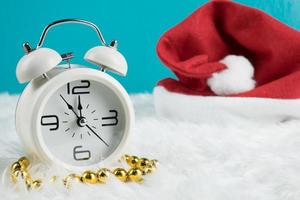 decorazione a tema del giorno di natale con cappello santa e orologio retrò bianco.copia spazio per testo.celebrazione natale e concetto di natale.su sfondo verde foto