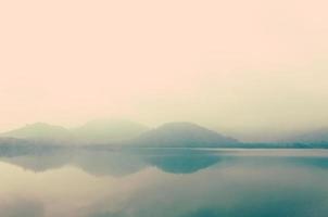 bellissimo paesaggio con vista sulle montagne e nebbia mattutina all'alba. incredibile sfondo naturale foto