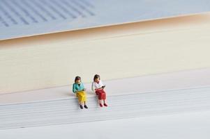 due persone in miniatura che leggono libri foto