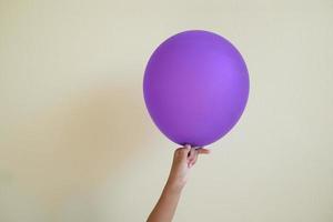 primo piano il bambino della mano che tiene il palloncino rosa isolato su sfondo bianco. foto