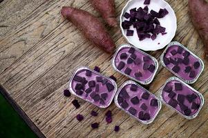 torta di patate dolci viola in tazza di alluminio sul tavolo di legno foto