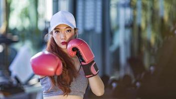 la donna asiatica fa esercizio di boxe in palestra per il fitness e uno stile di vita sano con spazio per la copia foto