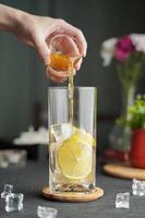 bicchiere di caffè espresso con succo di limone e limone fresco a fette su tavola di legno e spazio per la copia, cocktail estivo, caffè freddo o tè nero. foto