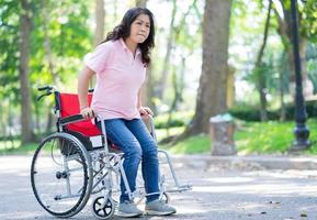 immagine di donna asiatica di mezza età seduta su sedia a rotelle foto