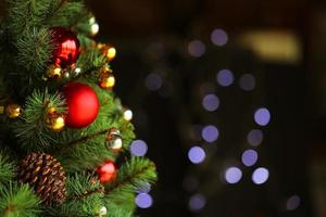 albero di natale decorato su sfondo sfocato scuro. foto