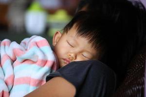 ritratto di bambino asiatico che dorme con la madre. concetto di festa della mamma di stile di vita della donna. foto