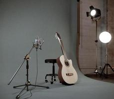 chitarra acustica e microfono in studio di registrazione con riflettori su background.3d rendering foto