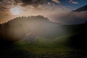 collina con casolare circondato da alberi in autunno foto