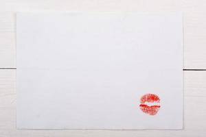foglio di carta bianco con un bacio su un tavolo bianco. foto