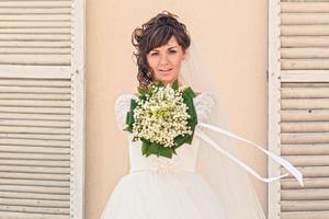 ragazza con un mazzo di fiori in piedi al muro foto