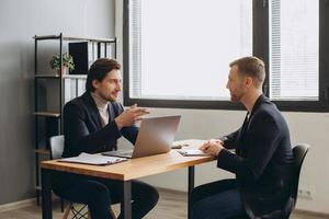 un uomo tiene una riunione di lavoro e firma un contratto, un impiego o un accordo. foto