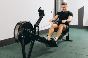 uomo che corre esercizio di canottaggio in palestra foto