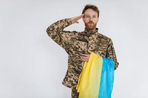 ritratto di un soldato ucraino in uniforme militare con una bandiera gialla e blu in onore foto