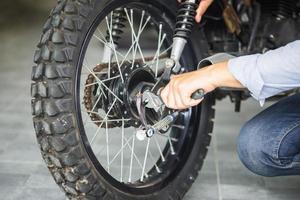 uomo che ripara moto in officina, meccanico che ripara moto in officina, riparazione e manutenzione foto