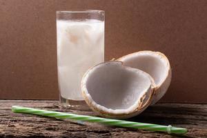 acqua di cocco in un bicchiere e cocco giovane foto