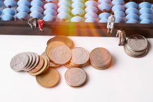 persone in miniatura. abaco e moneta. finanza e idee imprenditoriali. foto