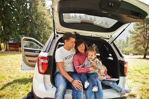 famiglia con due bambine all'interno del veicolo. bambini nel bagagliaio. viaggiare in auto in montagna, concetto di atmosfera. foto