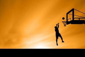 salto della siluetta del giocatore di basket foto