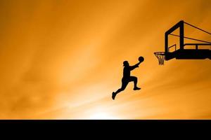 salto della siluetta del giocatore di basket foto