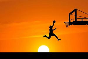 salto della siluetta del giocatore di basket foto