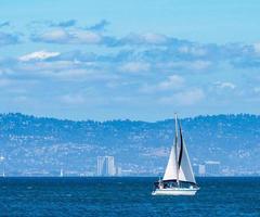 barca a vela in una giornata di sole con acqua blu e cielo blu foto