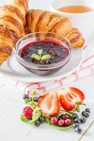 colazione - cornetti con straberry, lampone e mora, tè, marmellata foto