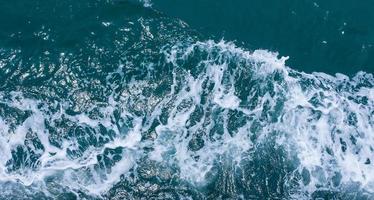 bellissime onde del mare con schiuma di colore blu e turchese. acqua di mare blu astratta con onda bianca. onde bianche e blu della strada della nave sull'oceano di mare dell'acqua. foto