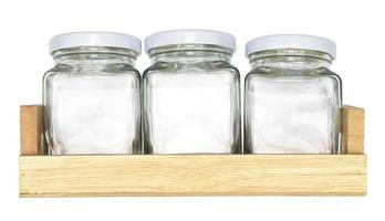 bottiglia di vetro su vassoio di legno isolato su sfondo bianco foto