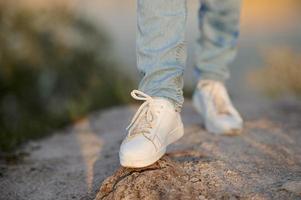 gambe femminili in jeans e scarpe da ginnastica. una gamba in una sfocatura. foto