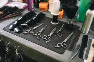 strumenti per tagliare i capelli con forbici, spazzola per capelli e pettine nel negozio di barbiere foto