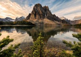 montagna rocciosa con riflesso di pino sul lago ceruleo nel parco provinciale di assiniboine foto