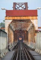 treno che corre su un'antica ferrovia sul lungo ponte bien ad hanoi foto