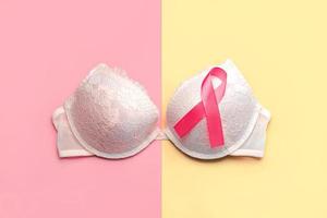 concetto di cancro al seno. vista dall'alto del reggiseno femminile e del nastro rosa simbolo consapevolezza del cancro al seno foto