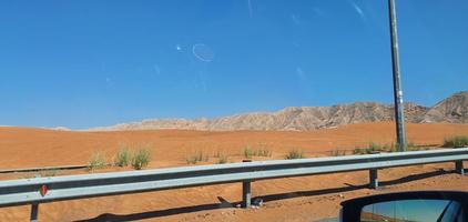 strada del deserto verso la duna di moreeb nell'area dell'oasi di liwa. emirato di abu dhabi, emirati arabi uniti foto