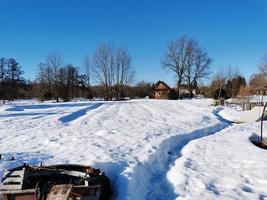 giornata di primavera nel villaggio russo neve bene cielo blu foto