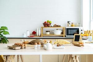 pane tostato a fette pane bianco, pane rustico, tagliato a pezzi, per colazione su fondo di legno, servito con uova e latte. concetto di preparazione del cibo, cucina sullo sfondo foto