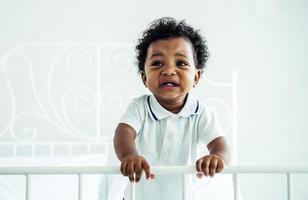 primo piano di adorabile bambino afroamericano che piange sul letto - persone di colore foto