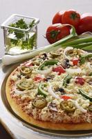 deliziosa pizza con verdure che la circondano nella cornice.