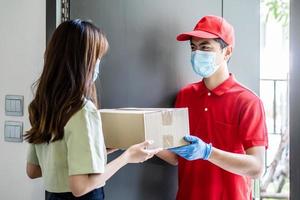 uomo di consegna in uniforme rossa che tiene scatole di pacchi a un cliente donna - concetto di servizio di corriere foto