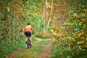 mountain biker femminile che guida la bici in natura prendendo parte a maratona, sport, fitness, salute foto