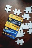 carte di credito e puzzle posti su un tavolo di legno - idee imprenditoriali foto