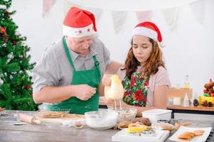 una giovane ragazza europea e suo padre stanno preparando gli ingredienti per cuocere il pan di zenzero foto