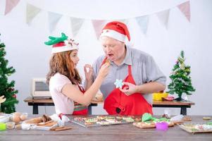 una giovane ragazza europea e suo padre provano il pan di zenzero che fa a Natale e Capodanno foto