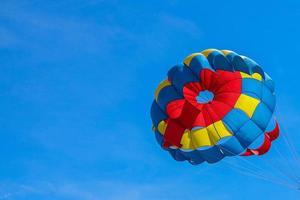 paracadute colorato sotto il cielo blu foto