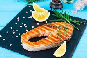 salmone alla griglia su tavola di pietra. sale salmone atlantico fritto alla griglia con limone foto