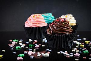 gustosi cupcakes colorati isolati su sfondo scuro. delizioso cupcake foto