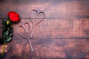 cuori di carta e rose rosse su pavimenti in legno foto