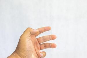 mano che tiene il telefono cellulare dell'esposizione del monitor trasparente in bianco digitale foto